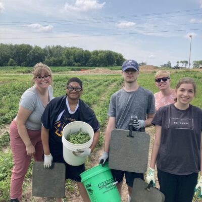 Group of participants posing with green beans picked